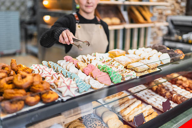 Pastry chef arranging cookies in display case