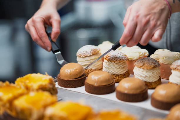Pastry chef arranging cream puffs and tarts
