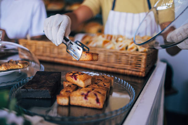 Person serving freshly baked goods in bakery