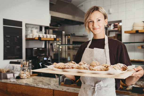 Welcoming baker holding almond croissants